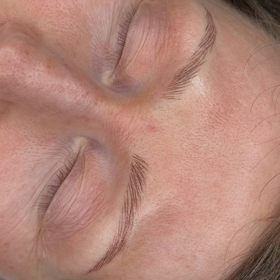 Close-up before and after of a microbladed brow showing fine, realistic hair strokes.